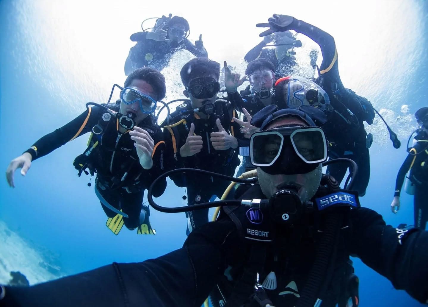 A group of divers giving a thumbs up on an underwater selfie in Sogod Bay